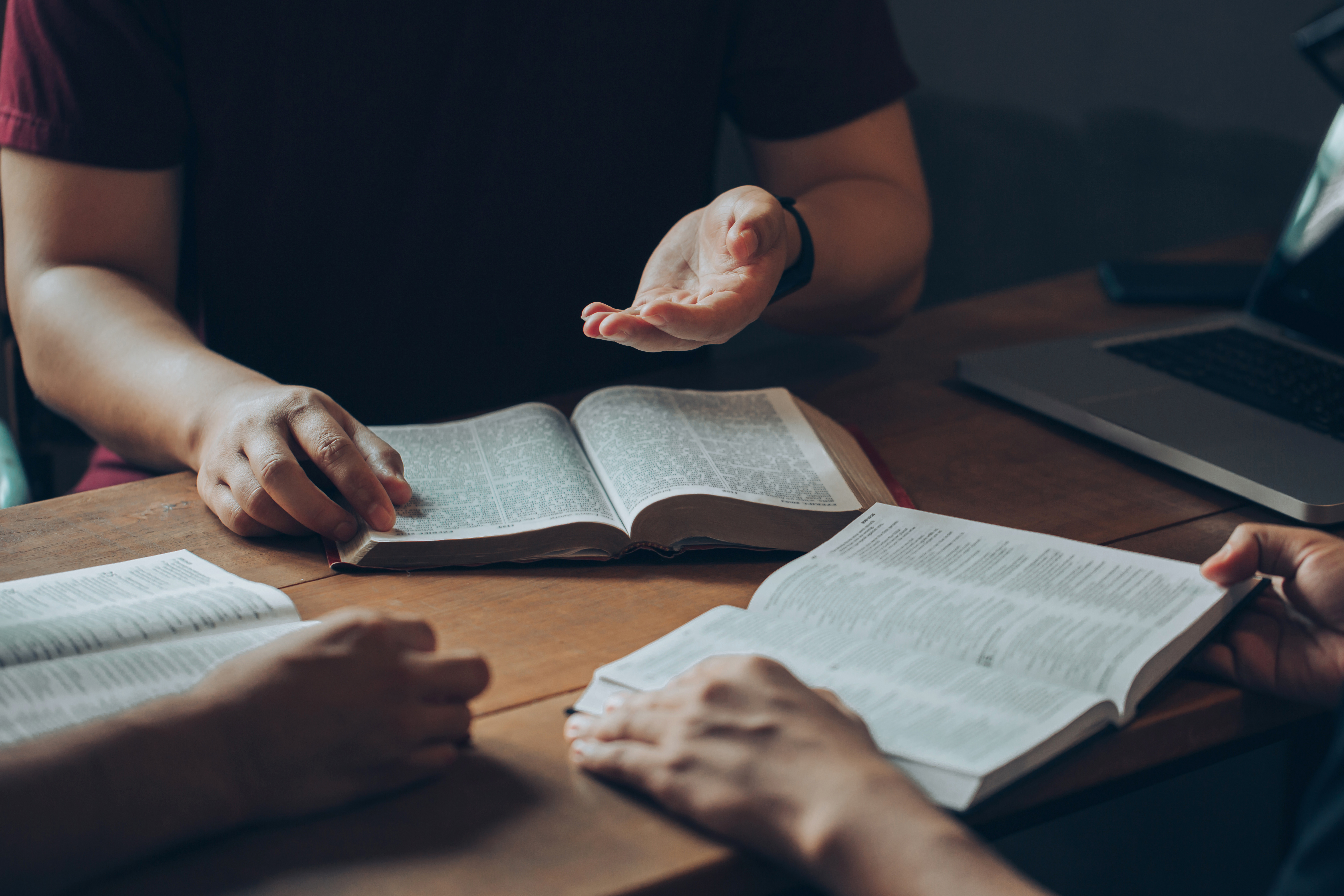 Bible Study group in a circle holding Bibles